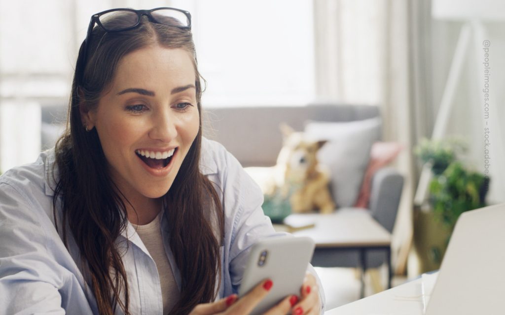 NEWSLETTER Format Blogartikel Frau schaut begeistert auf ihr Handy